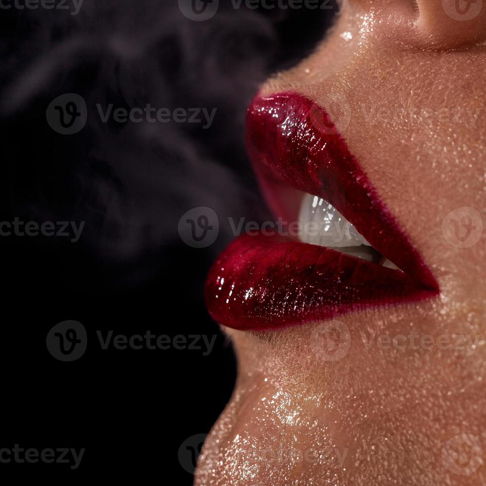 foto macro dos lábios de mulher molhada com fumaça no fundo