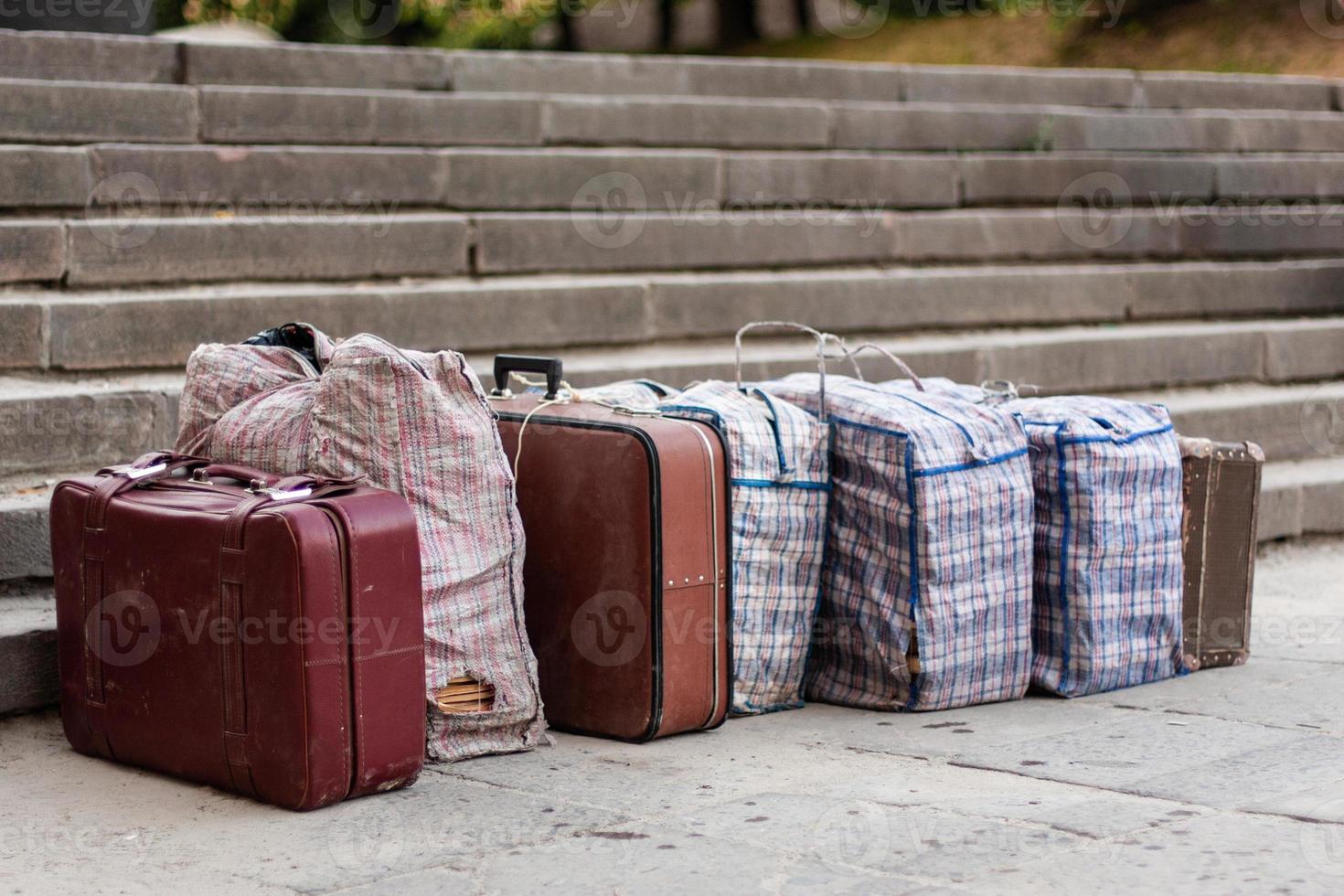 muitas malas e bolsas estão alinhadas na rua. foto