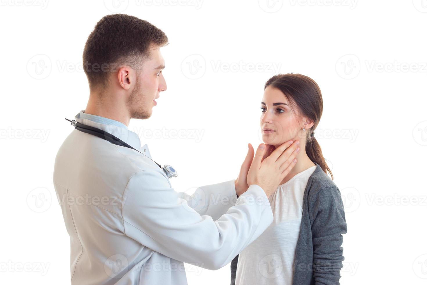 jovem médico examina mãos garganta linda garota close-up foto