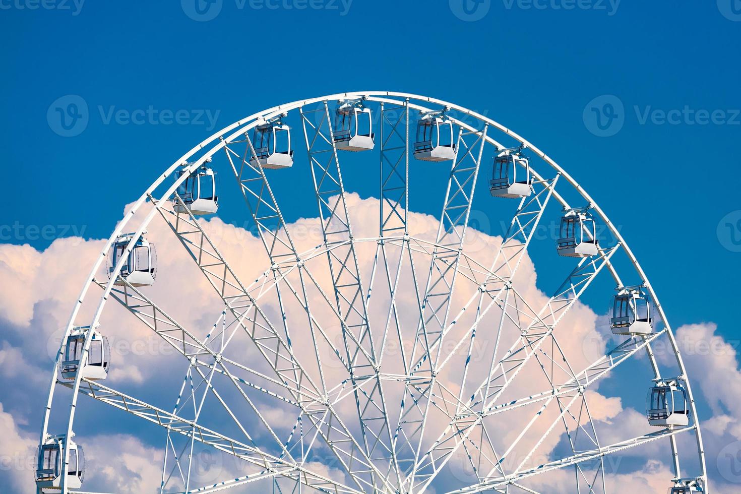 grande roda gigante contra o céu azul e nuvens brancas foto