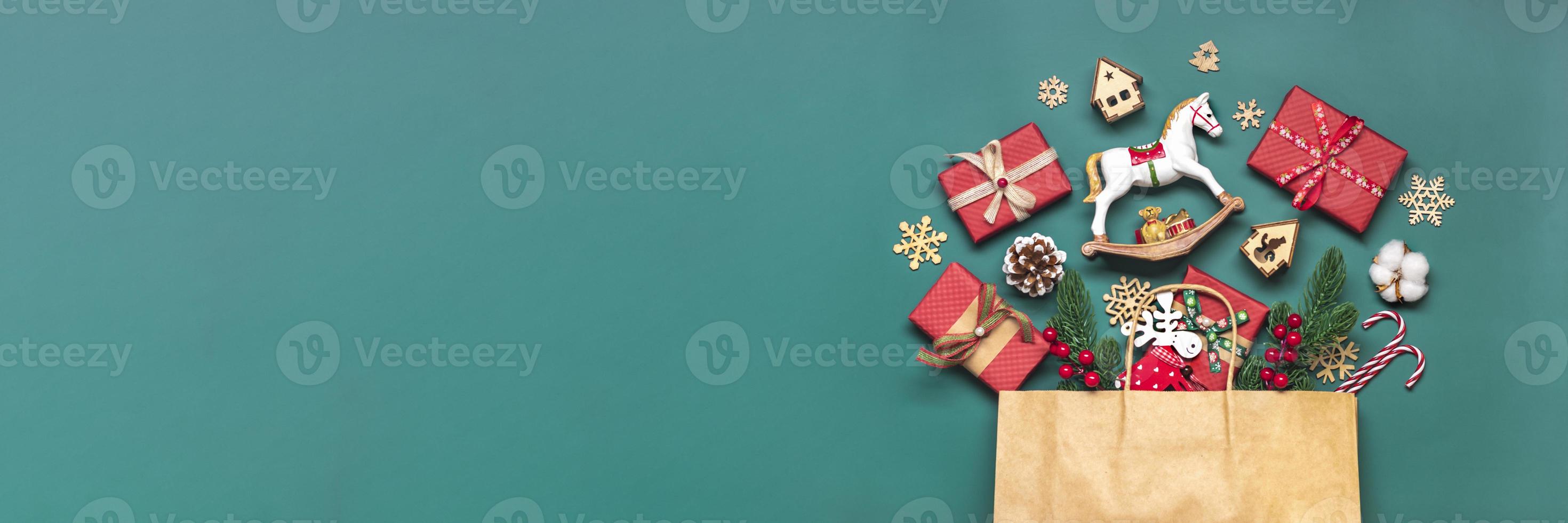 caixas de presente vermelhas embrulhadas à mão decoradas com fitas, flocos de neve e números, decorações de natal e decoração em saco na mesa verde conceito de calendário do advento de natal vista superior cartão de férias plano leigo foto