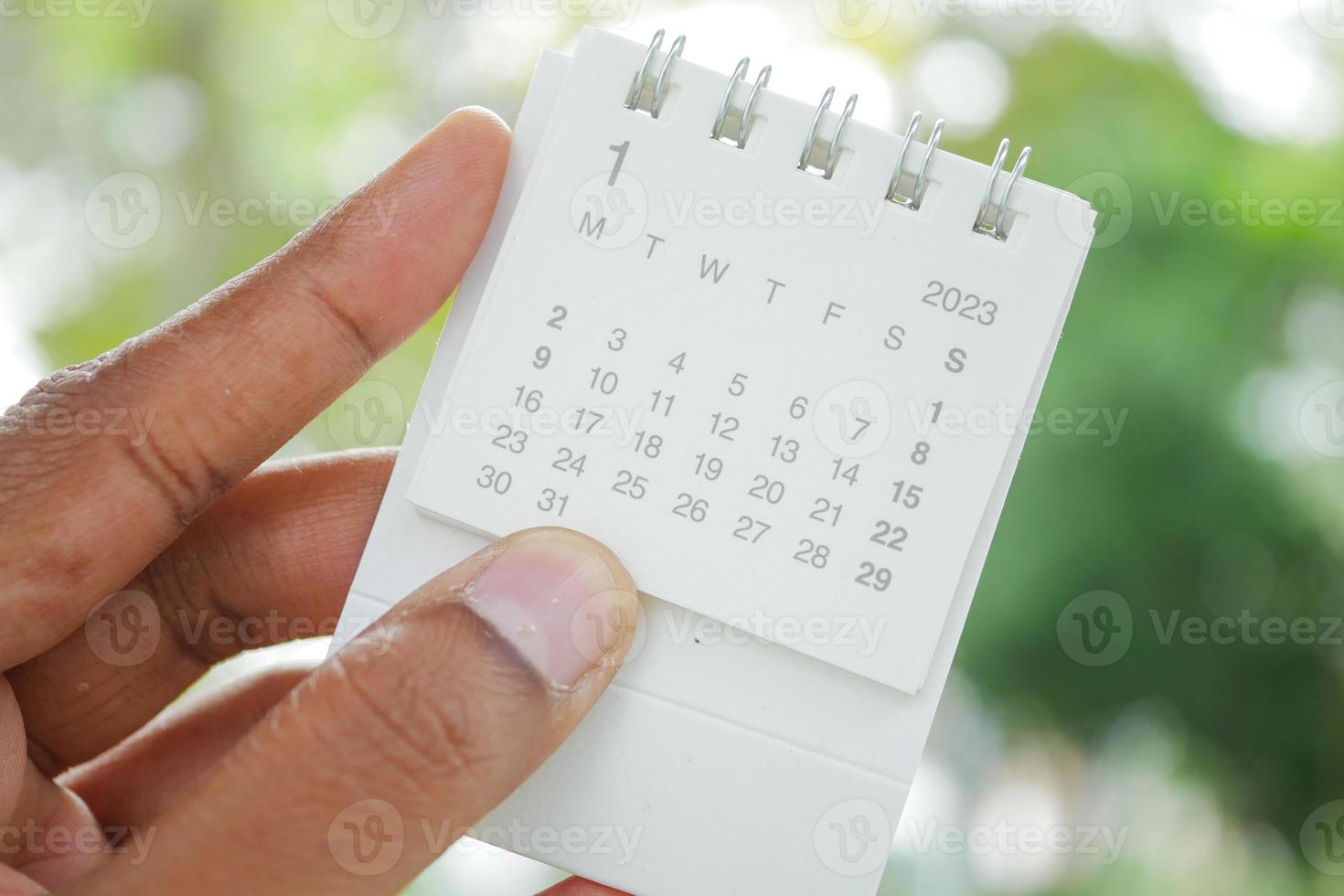 segurando um calendário de 2023 anos ao ar livre foto