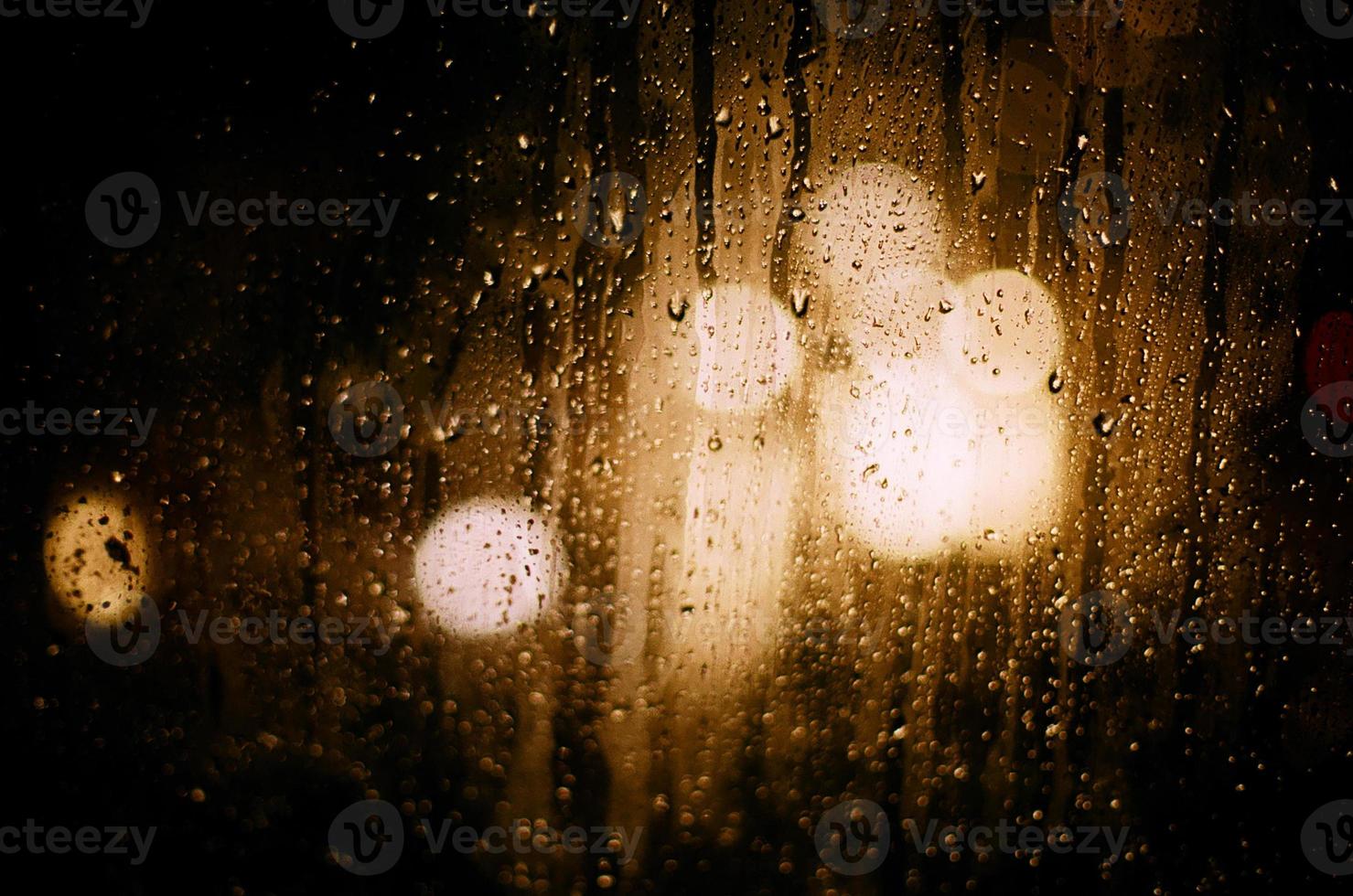 nos reflexos redondos de vidro da luz borrada dos faróis dos carros durante a chuva. foto