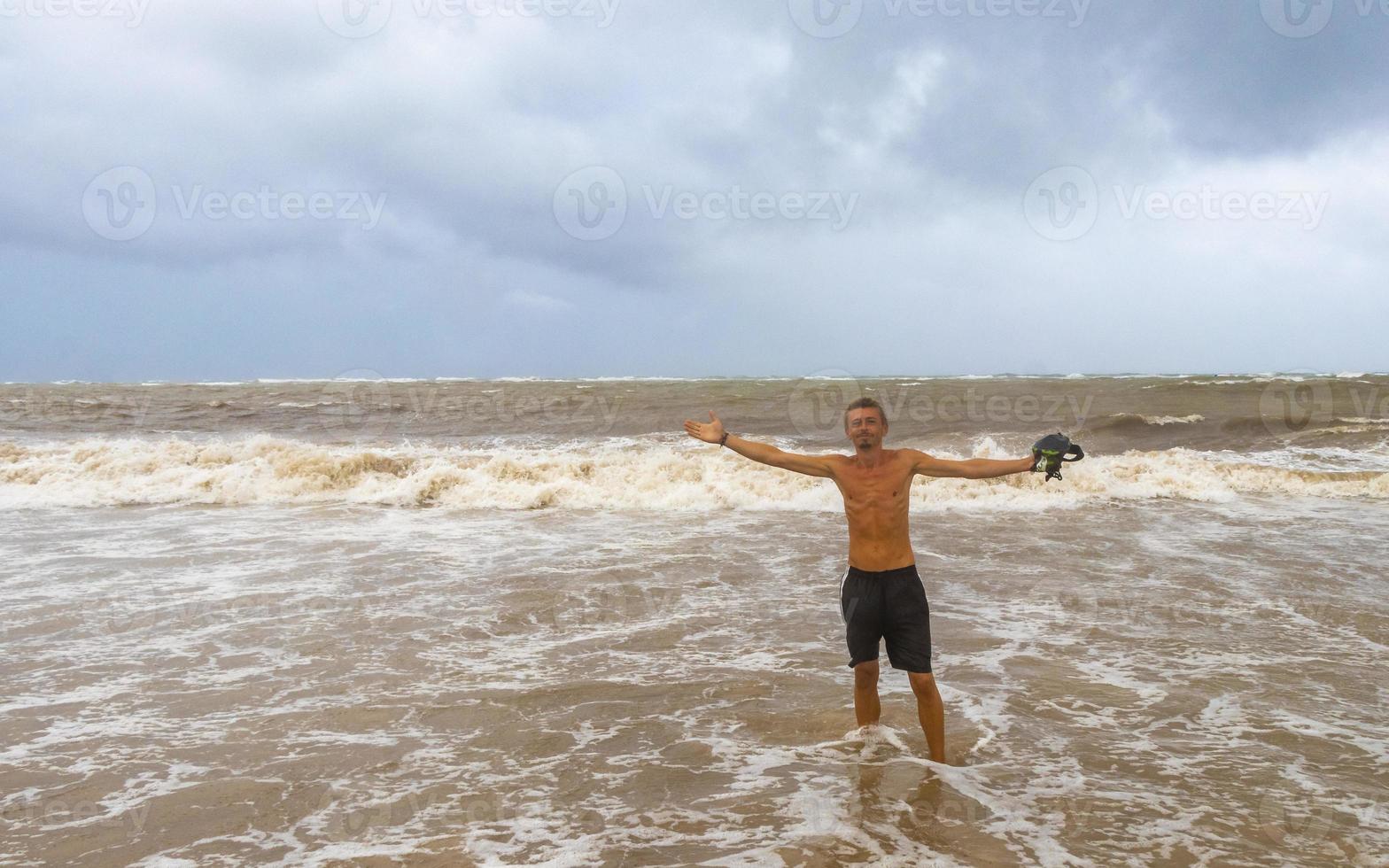 homem está na praia durante o furacão e gosta do méxico. foto