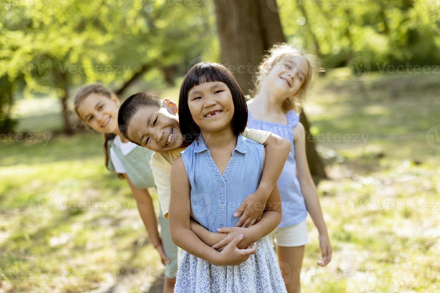 grupo de crianças asiáticas e caucasianas se divertindo no parque foto
