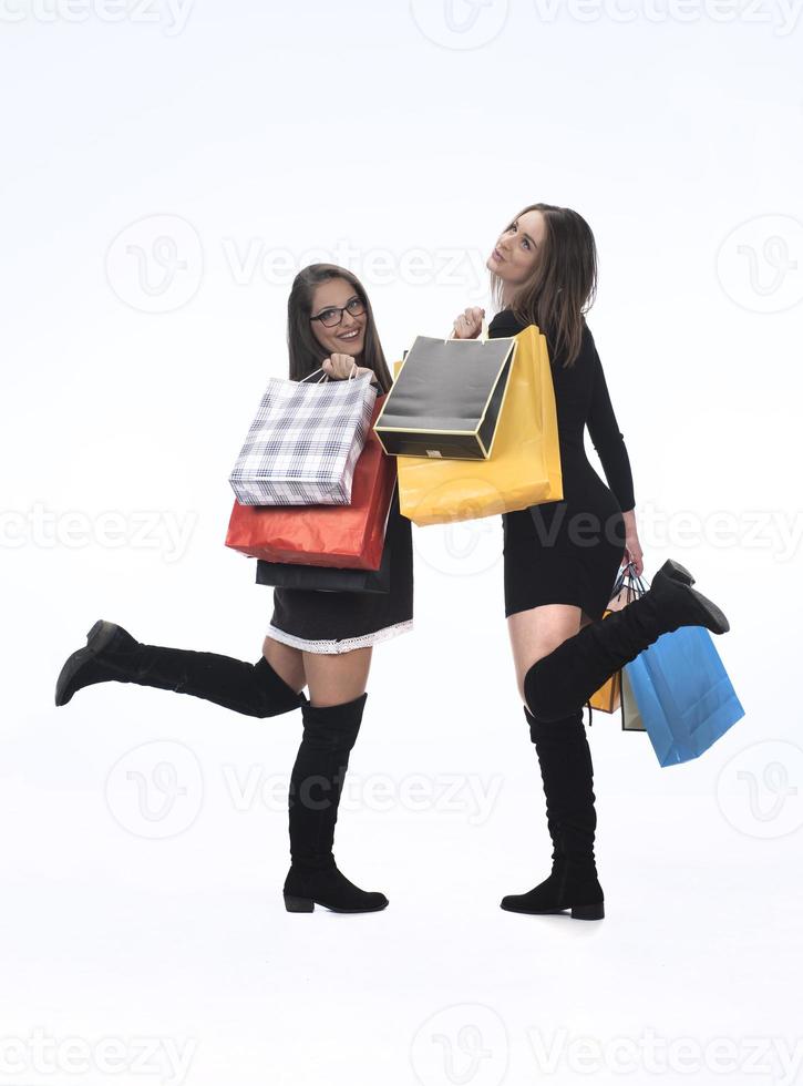 duas amigas felizes com sacola de compras em fundo de estúdio isolado. foto