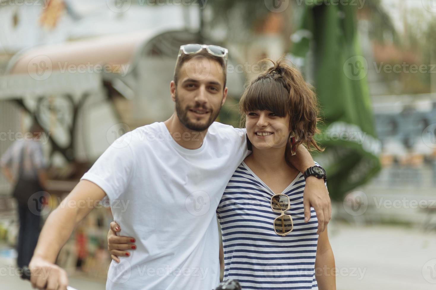 casal de turistas se divertindo andando na rua da cidade no feriado - amigos felizes rindo juntos nas férias - conceito de pessoas e feriados foto