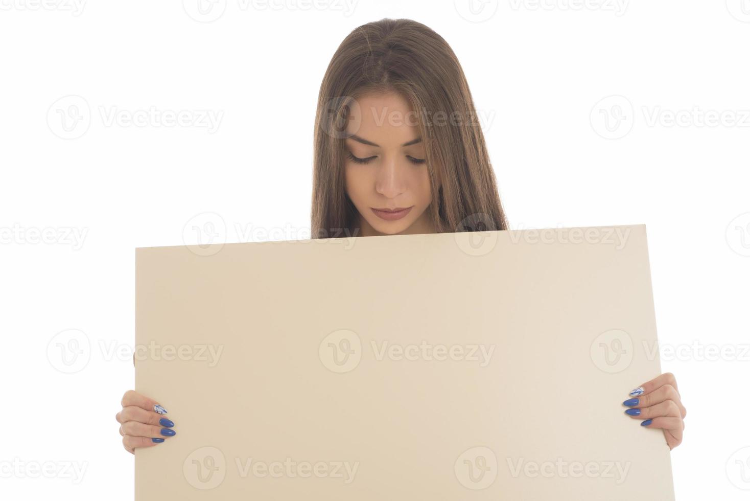 menina sorridente segurando a placa em branco. retrato de estúdio de jovem com cartão de sinal. isolado. foto