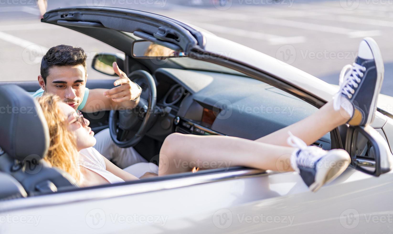 amigos se divertindo na viagem de carro ao redor do mundo. casal apaixonado com os braços para cima em um carro conversível. foto