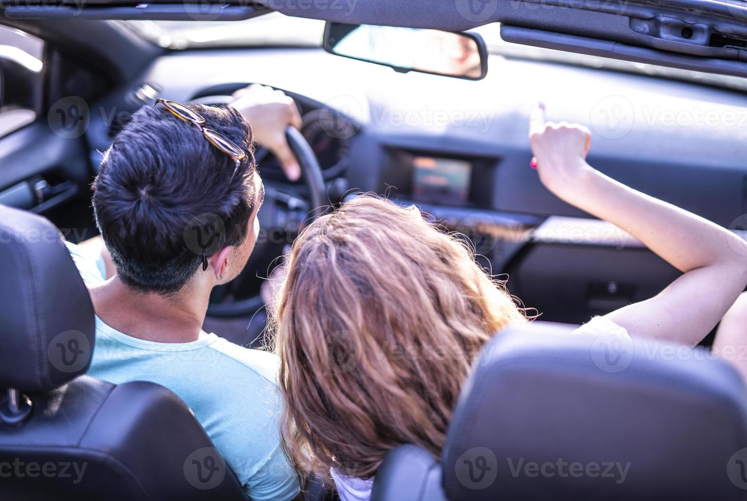 amigos se divertindo na viagem de carro ao redor do mundo. casal apaixonado com os braços para cima em um carro conversível. foto