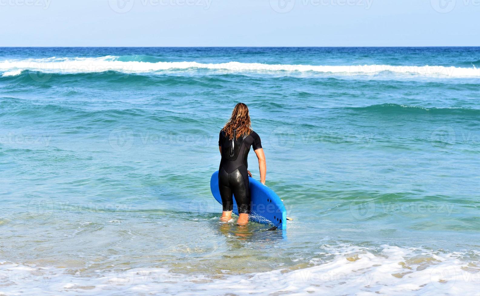 um homem está de pé com uma onda nas mãos na praia do mar. foto