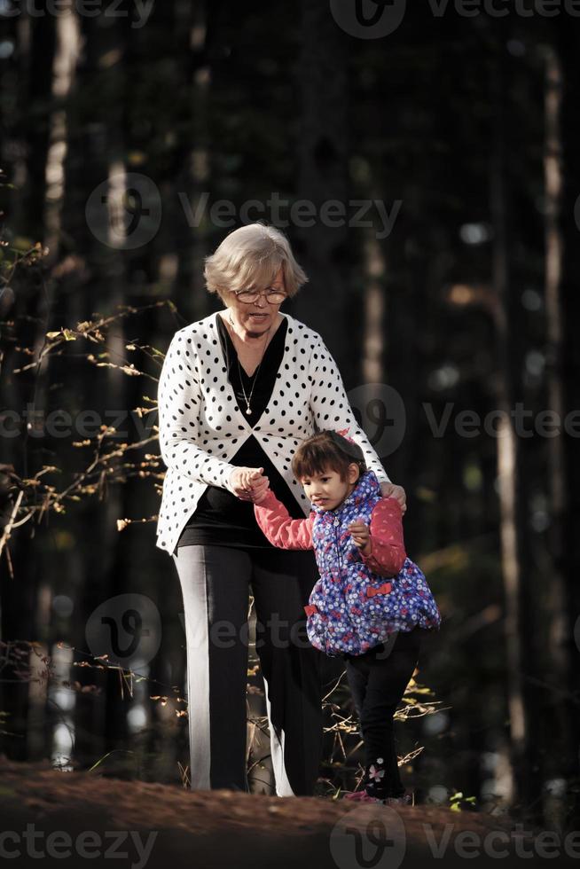 avó e sua neta autista curtindo férias juntos ao ar livre, deitada na grama verde no cobertor e sorrindo para a câmera. lazer estilo de vida familiar, felicidade e momentos. foto