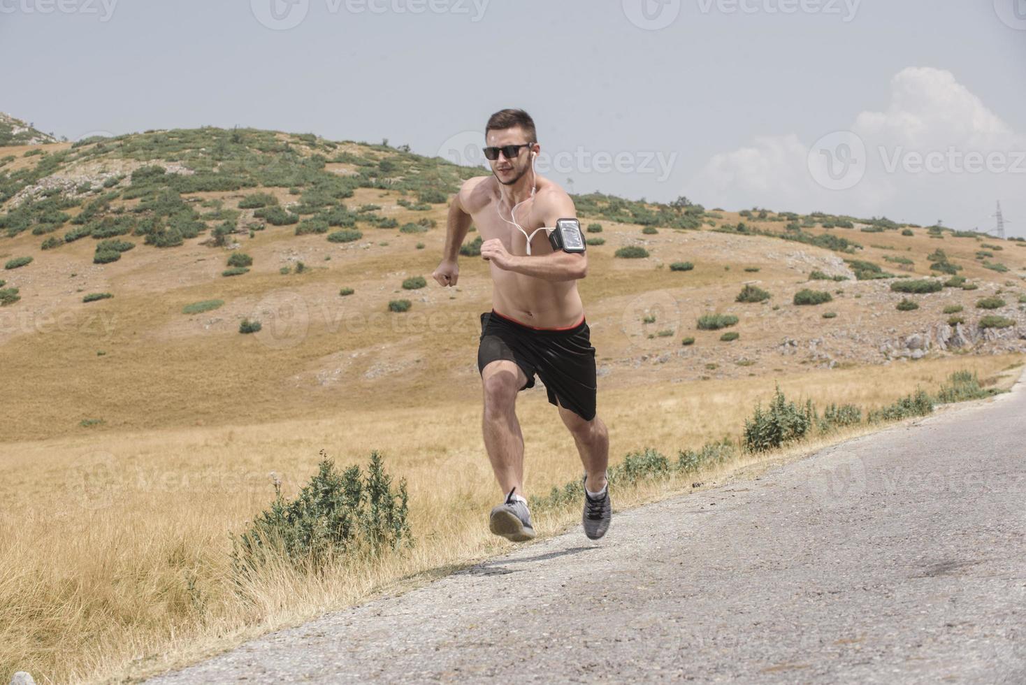 corredor de homem desportivo correndo no planalto da montanha no verão foto