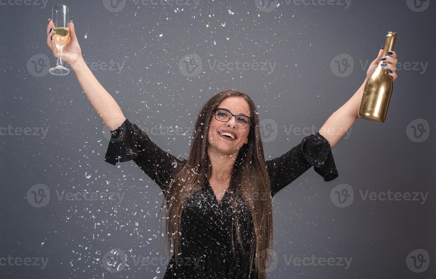 linda mulher comemorando o ano novo com confete e champanhe foto