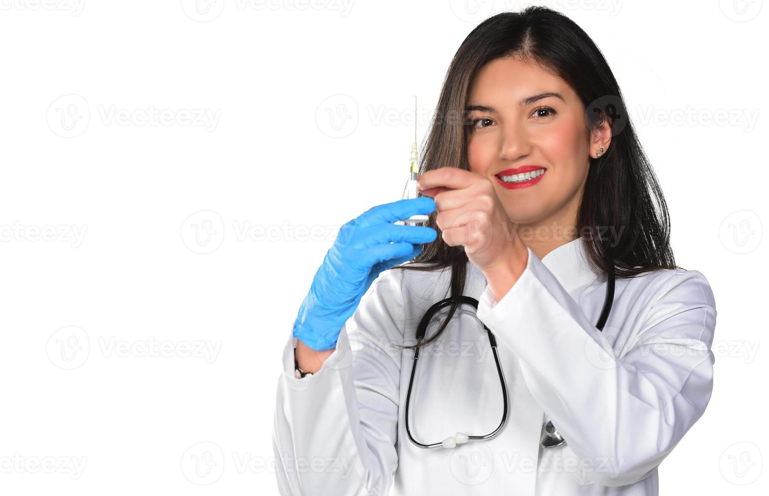 uma jovem médica com estetoscópio preparando uma injeção, isolada no fundo branco foto