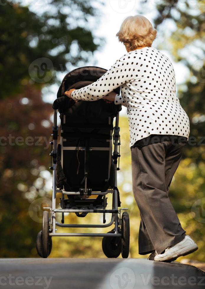 avó e sua neta autista curtindo férias juntos ao ar livre, deitada na grama verde no cobertor e sorrindo para a câmera. lazer estilo de vida familiar, felicidade e momentos. foto