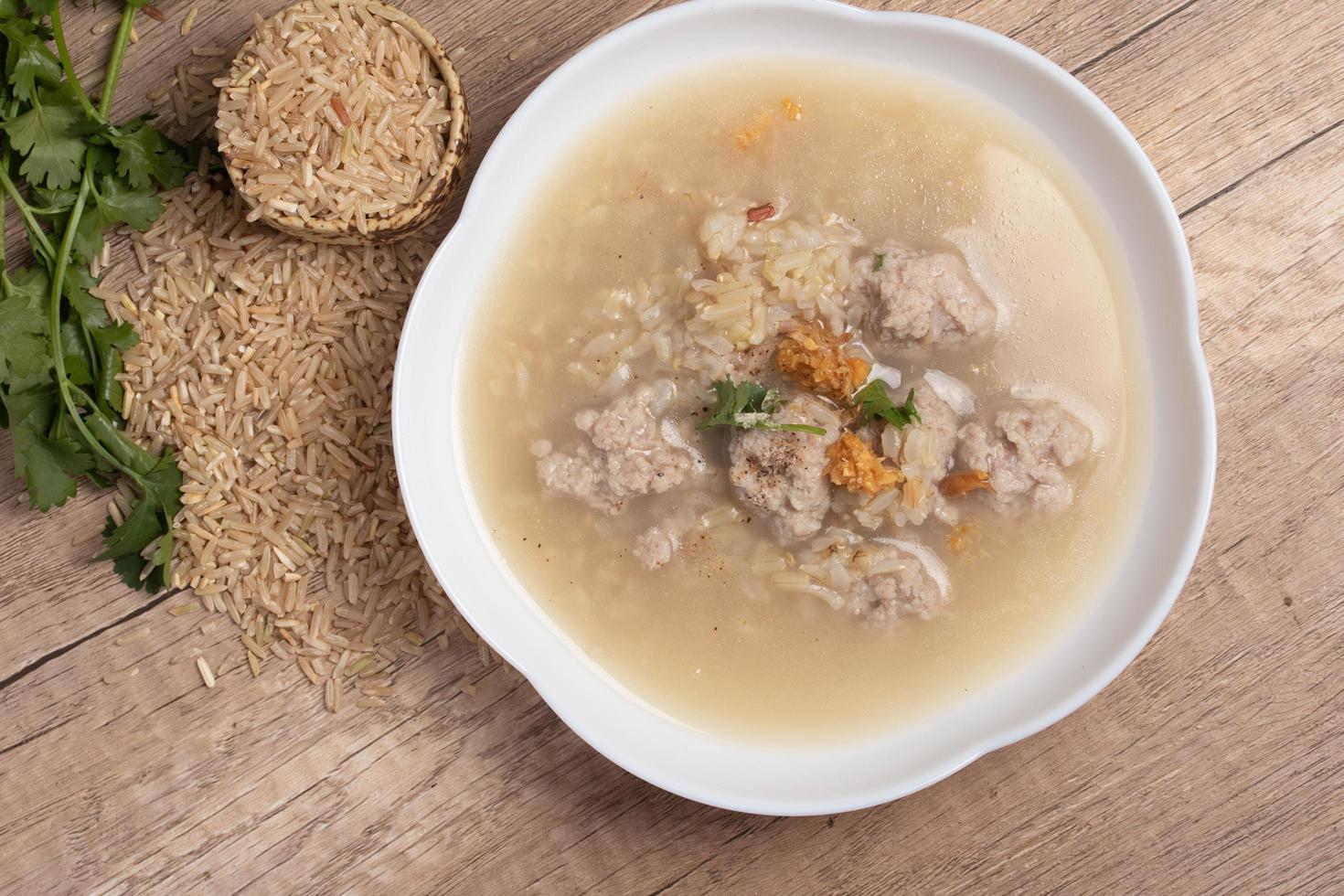 mingau de arroz integral de jasmim com carne de porco em fundo de madeira espaço de cópia de comida saudável foto