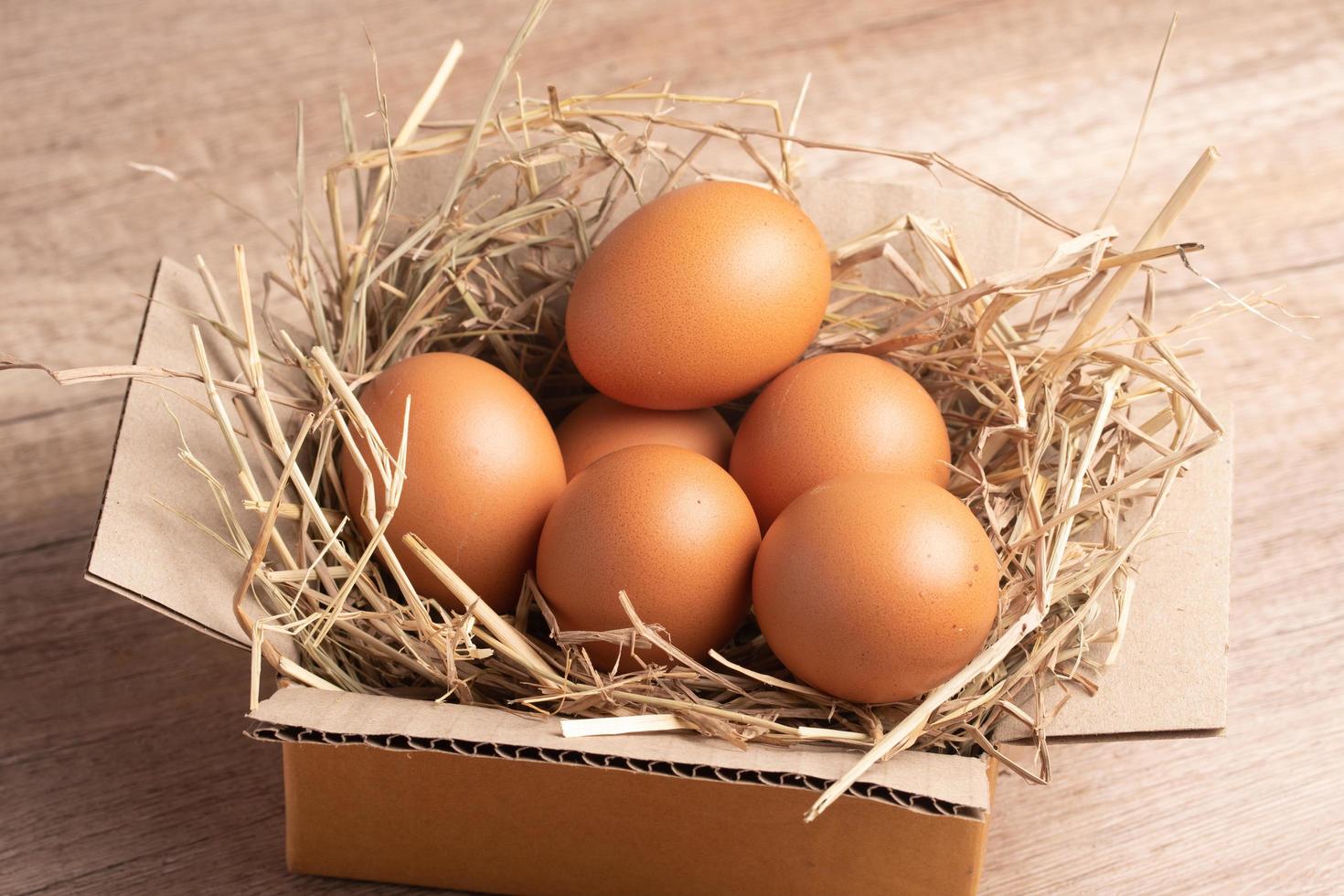 ovos de galinha na palha de arroz colocados em uma caixa foto