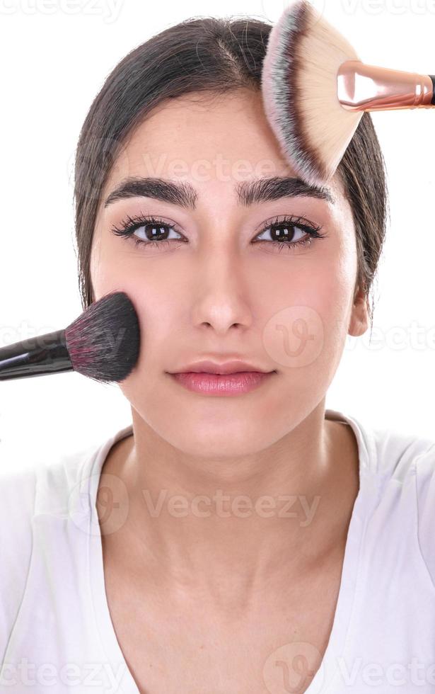 mulher fazendo maquiagem, olhando no espelho. foto