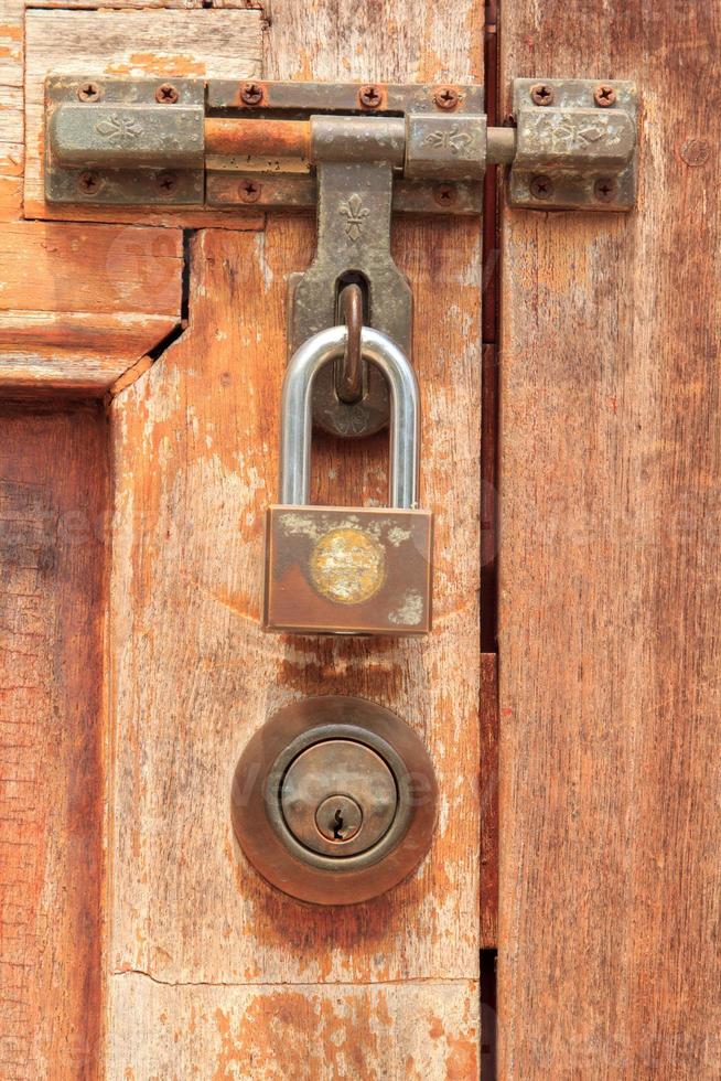 porta de madeira marrom tem uma chave e uma fechadura e uma maçaneta para trancar a porta para evitar que ladrões e ladrões roubem seus pertences e objetos de valor. é uma porta de madeira antiga foto