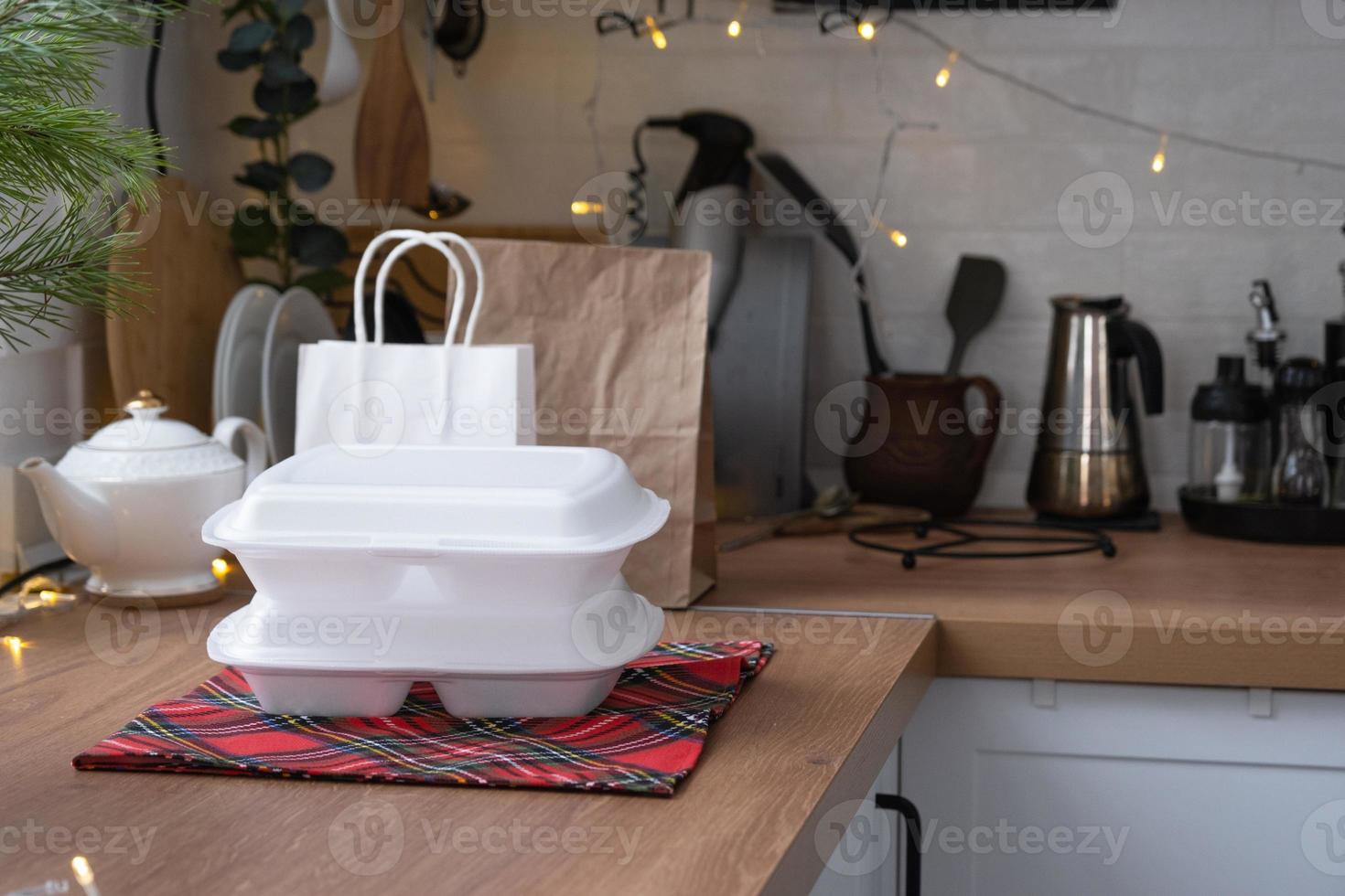 recipientes de serviço de entrega de comida na mesa na cozinha branca, servidos festivamente para a celebração do natal e ano novo. economizando tempo, pedido quente, caixa de plástico descartável, pacote de artesanato. brincar foto