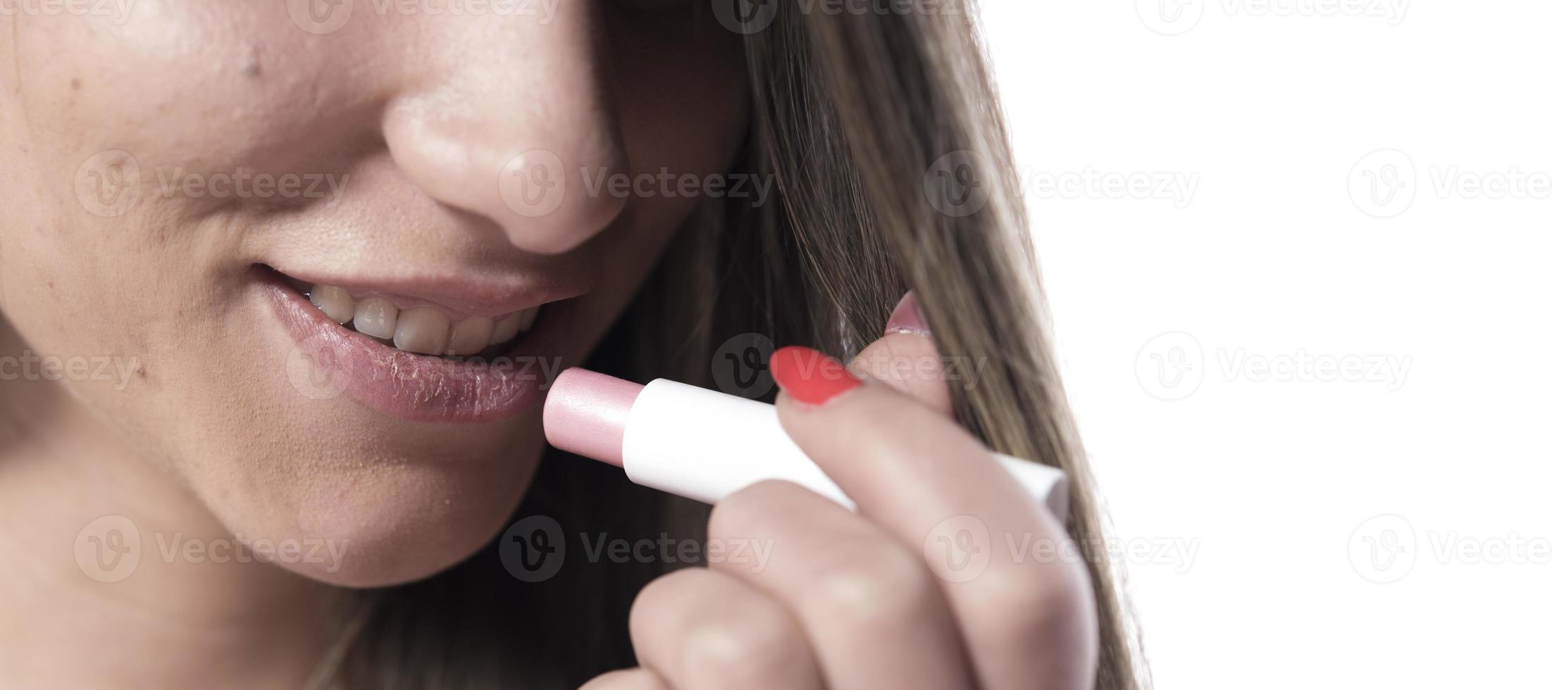 cuidados com a pele dos lábios. rosto de mulher bonita com lábios carnudos sensuais, aplicando protetor labial higiênico, bastão de cuidados com os lábios. closeup do rosto feminino com pele macia, colocando batom protetor labial. conceito de cosméticos de beleza foto