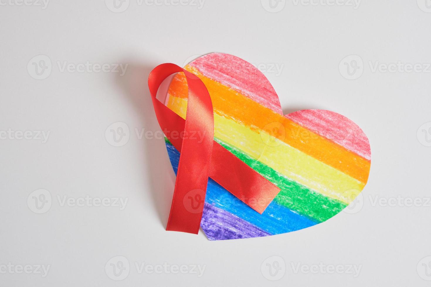 pare de aids, conceito de hiv. fita vermelha contra o coração com as cores do orgulho da bandeira lgbt foto