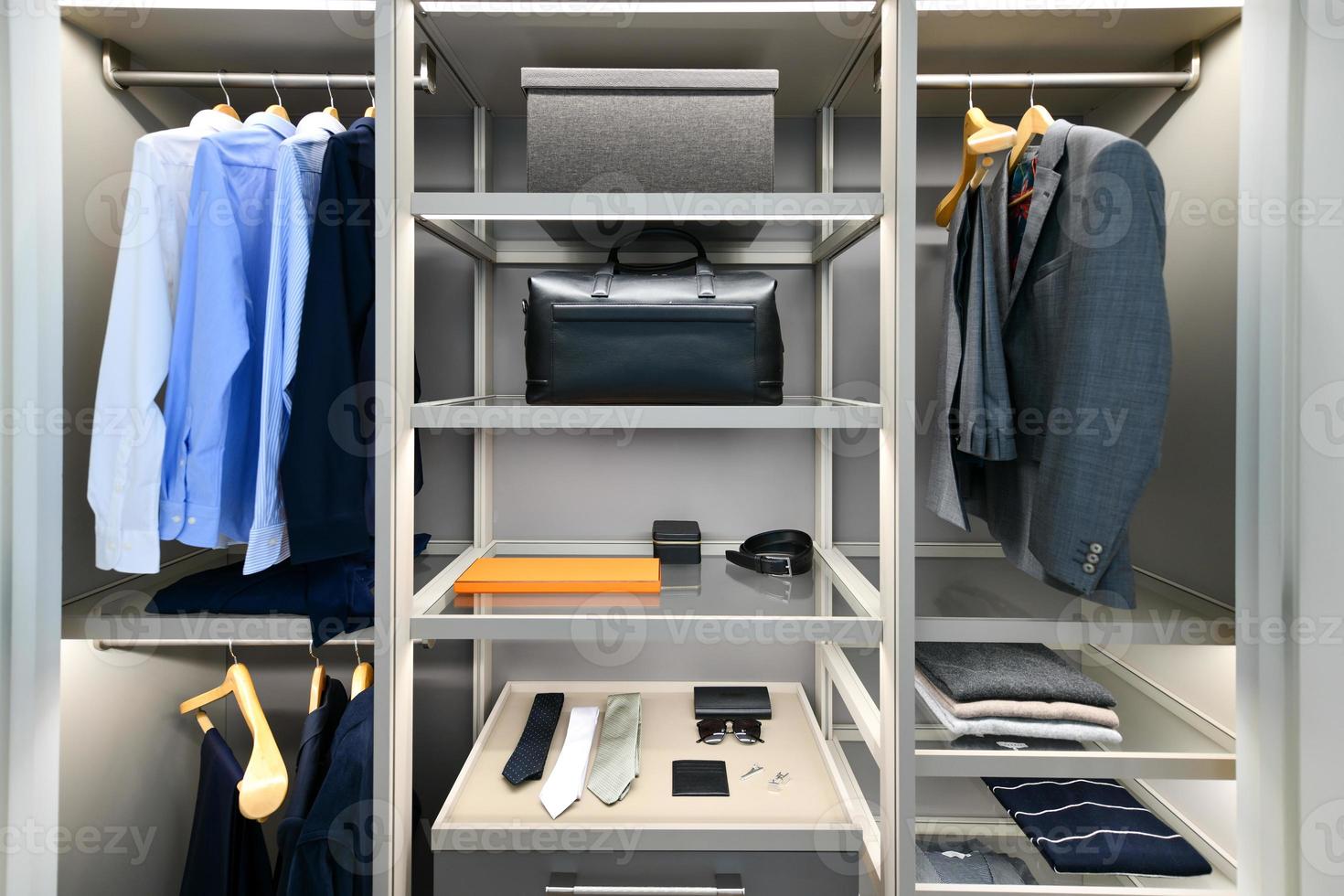 armário masculino bem organizado com terno, camisa, gravata e outros trajes de negócios. foto