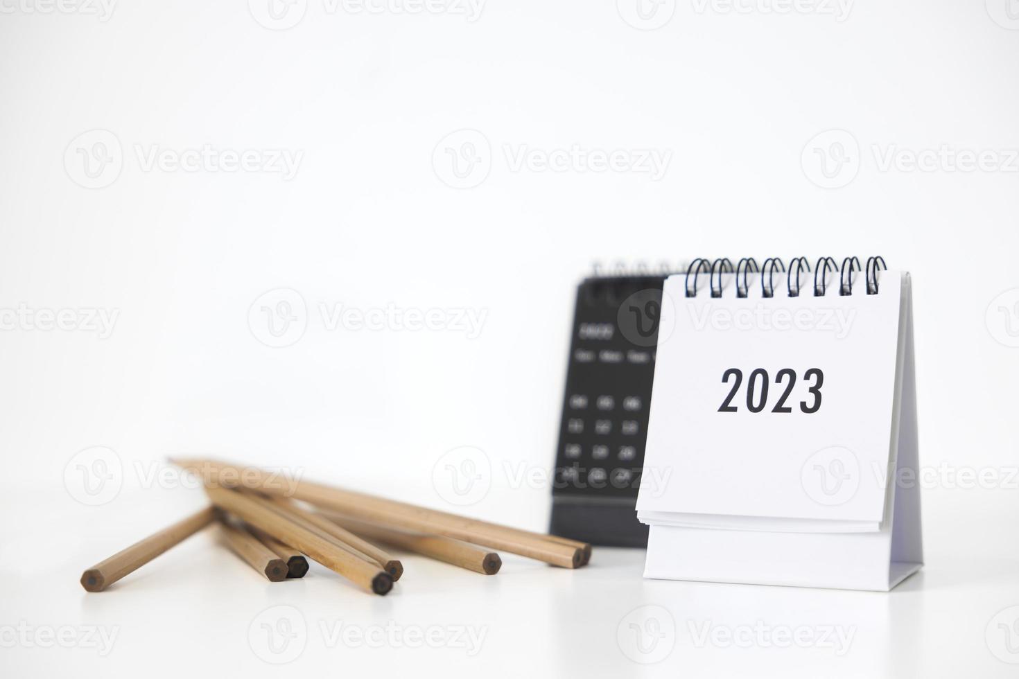 Calendário de negócios de 2023 e lápis na mesa de escritório no dia de ano novo. fazer um plano de trabalho para o início do ano. conceito sobre celebração, negócios, natal, ano novo. foto