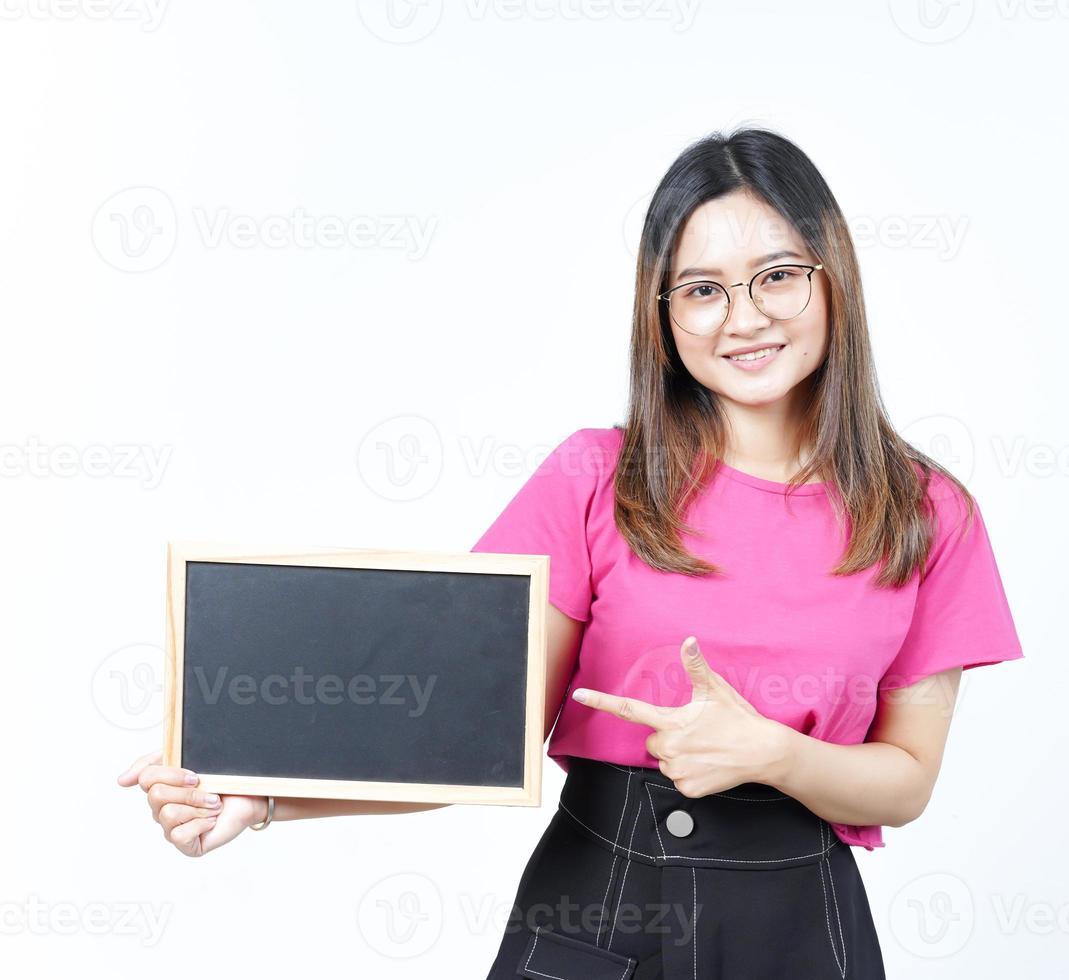 mostrando, apresentando e segurando o quadro-negro em branco da bela mulher asiática isolada no branco foto