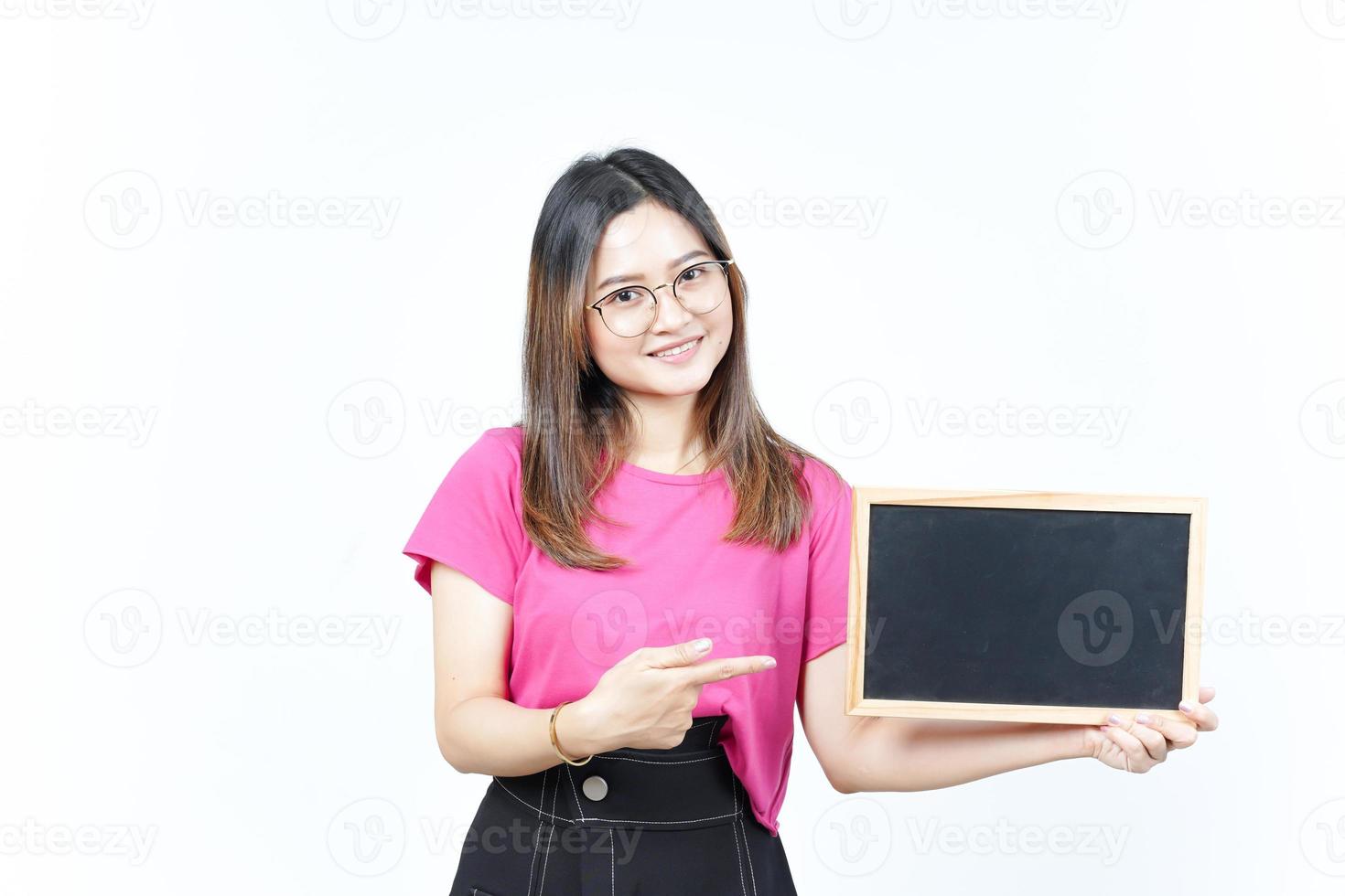 mostrando, apresentando e segurando o quadro-negro em branco da bela mulher asiática isolada no branco foto