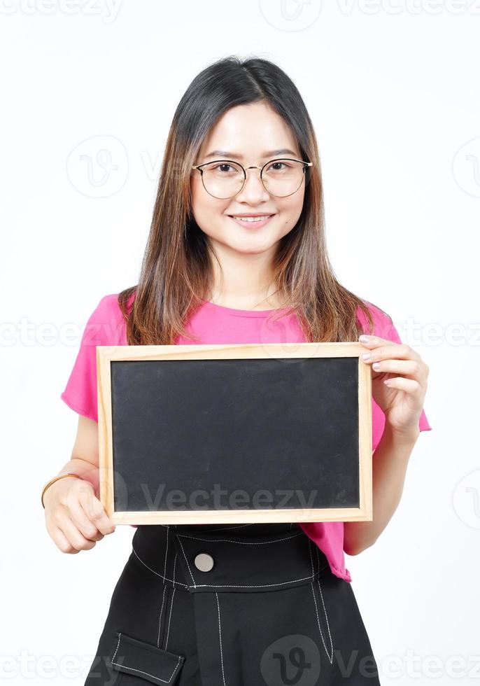 mostrando, apresentando e segurando o quadro-negro em branco da bela mulher asiática isolada no branco foto