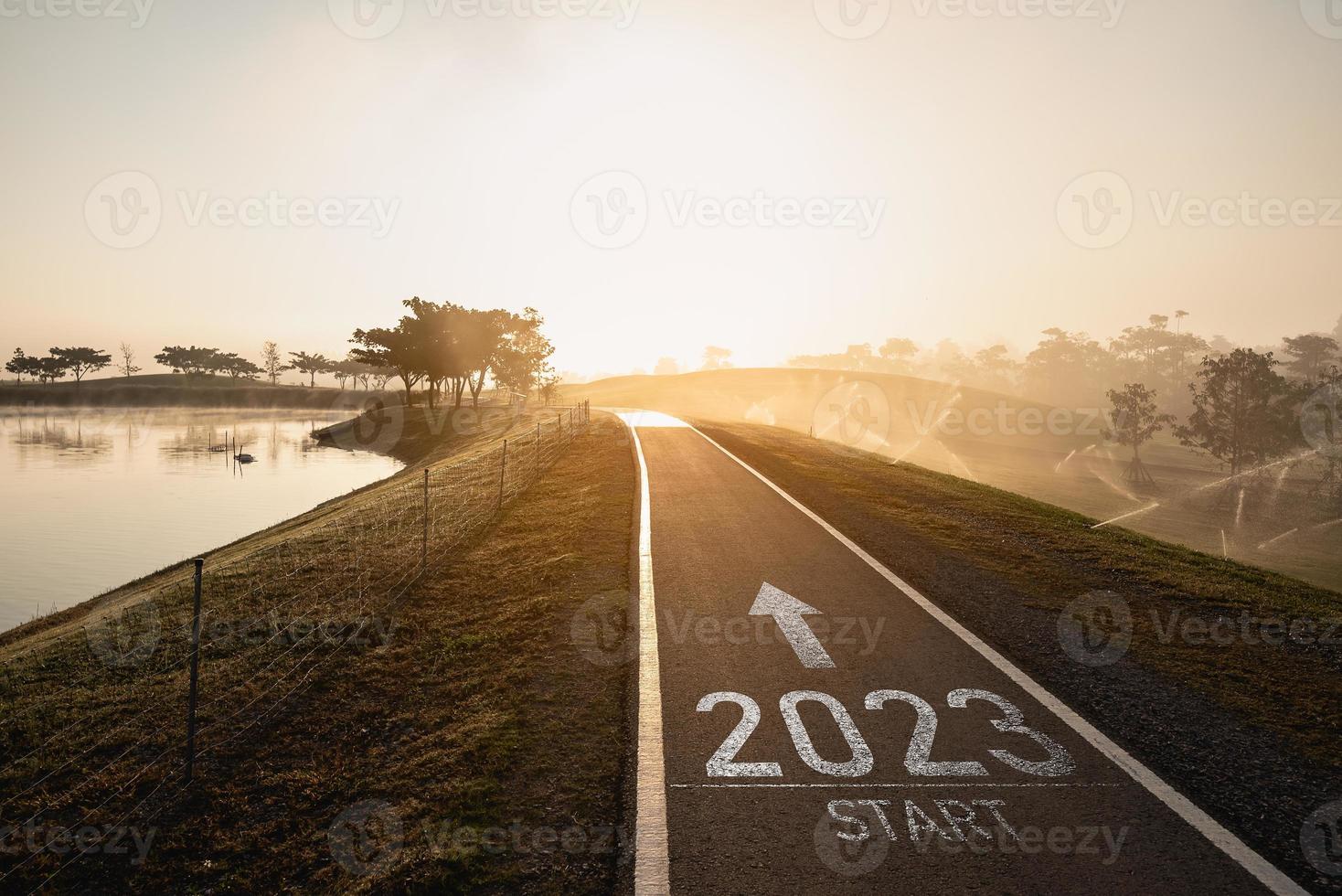 feliz ano novo 2023,2023 simboliza o início do ano novo. a carta começa o ano novo de 2023 na estrada na estrada da rota da natureza perto do rio no conceito de papel de parede verde da ecologia do nascer do sol da manhã. foto