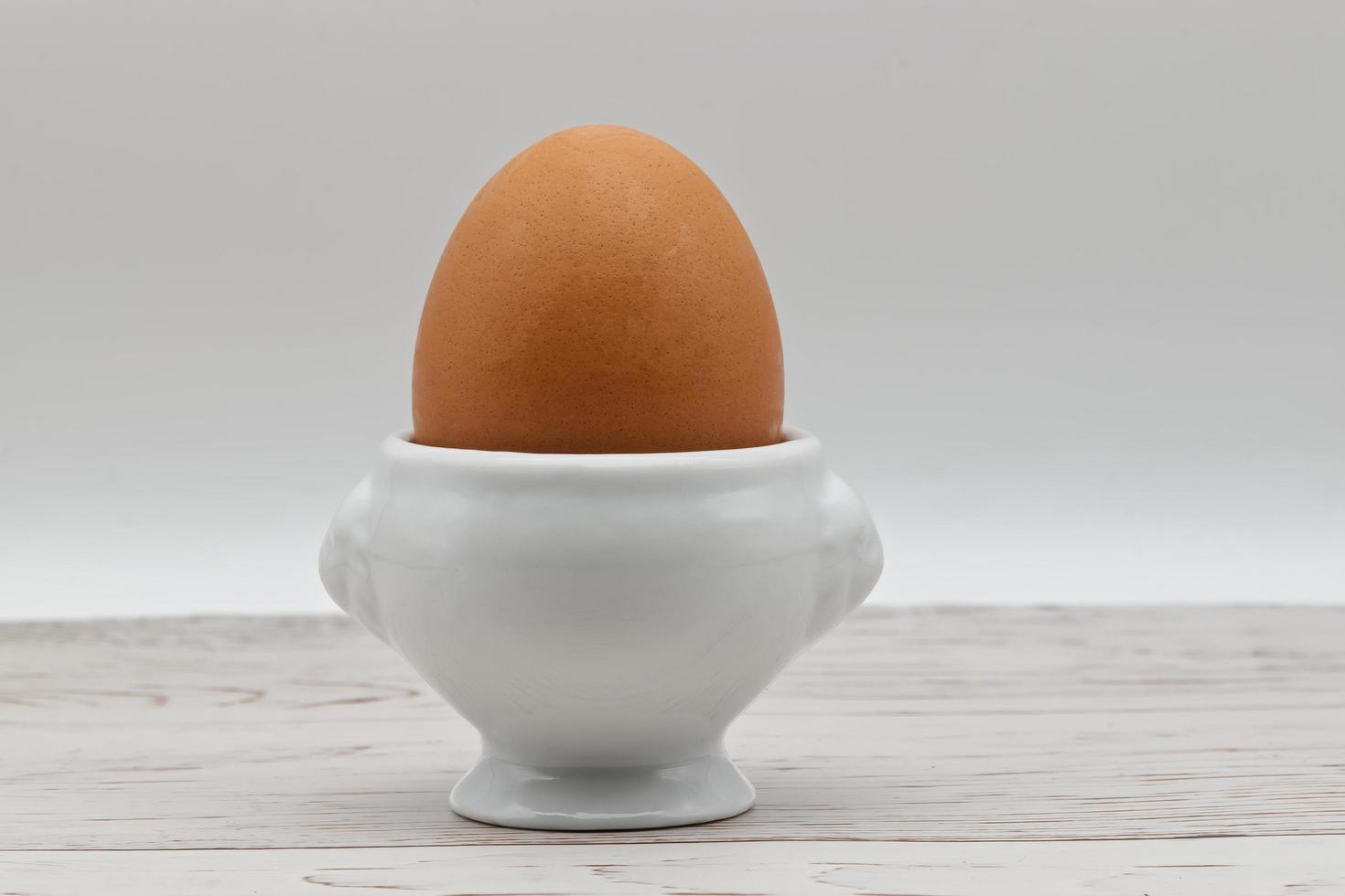 ovo fresco em um eggcup isolado no fundo branco. comida tradicional no café da manhã saudável. foto