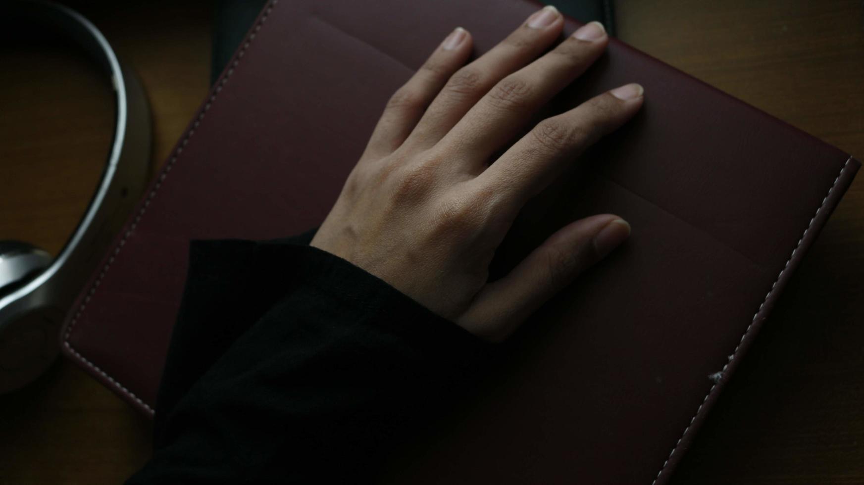 closeup da mão de uma mulher em um livro em um ambiente sombrio foto