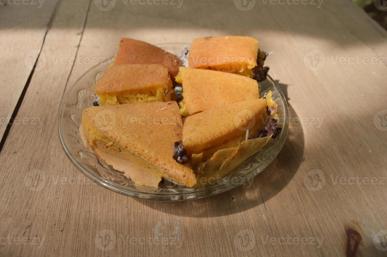 terang bulan comida feita de farinha e recheada com arroz pegajoso preto originário da indonésia. com placas e fundo de madeira. foto