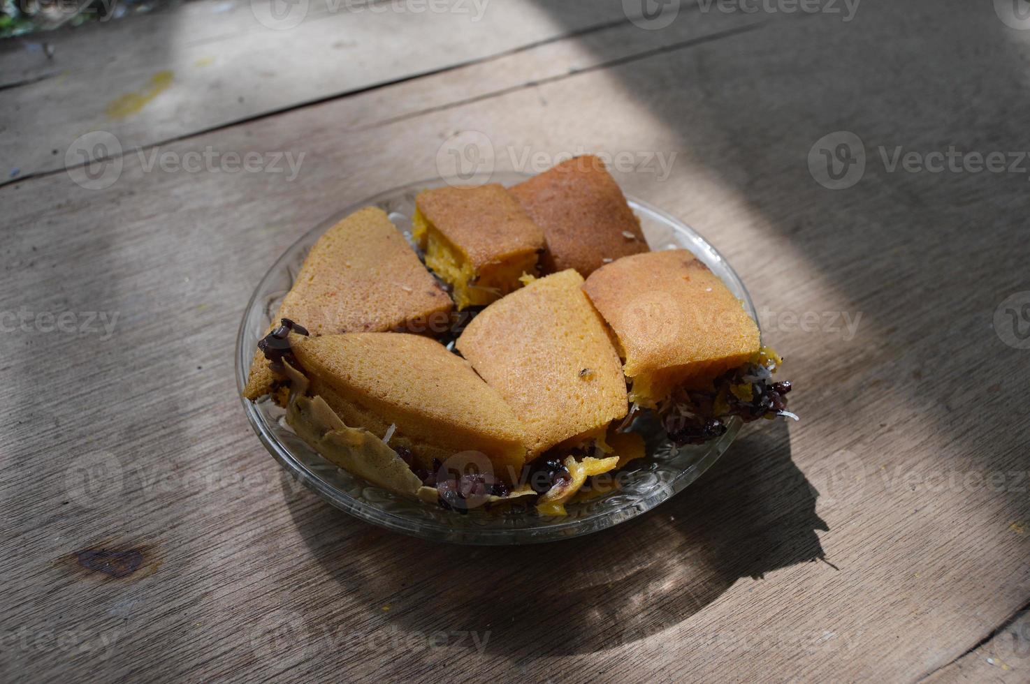 terang bulan comida feita de farinha e recheada com arroz pegajoso preto originário da indonésia. com placas e fundo de madeira. foto