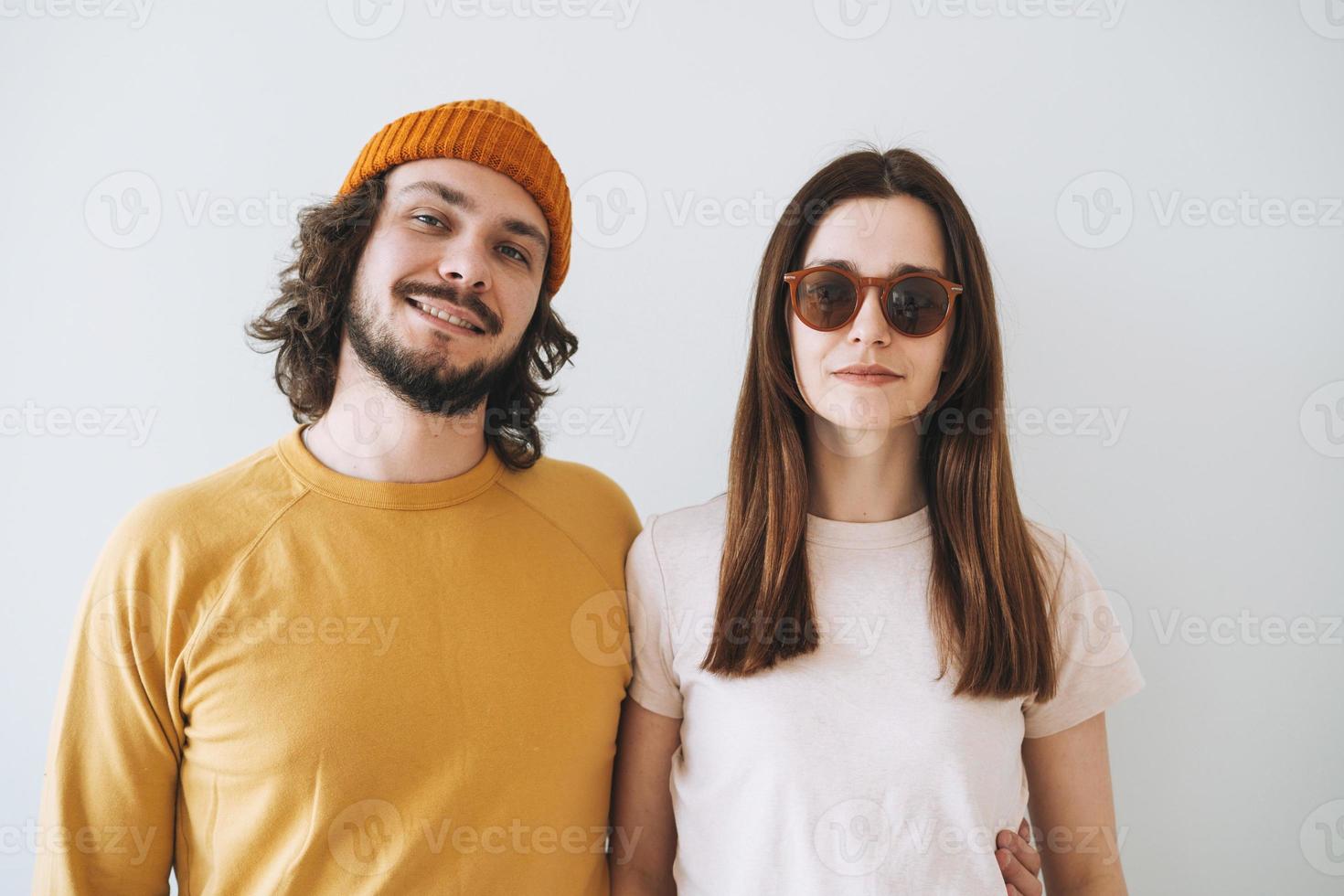 retrato de casal sorridente jovens descolados da família contra a parede cinza foto