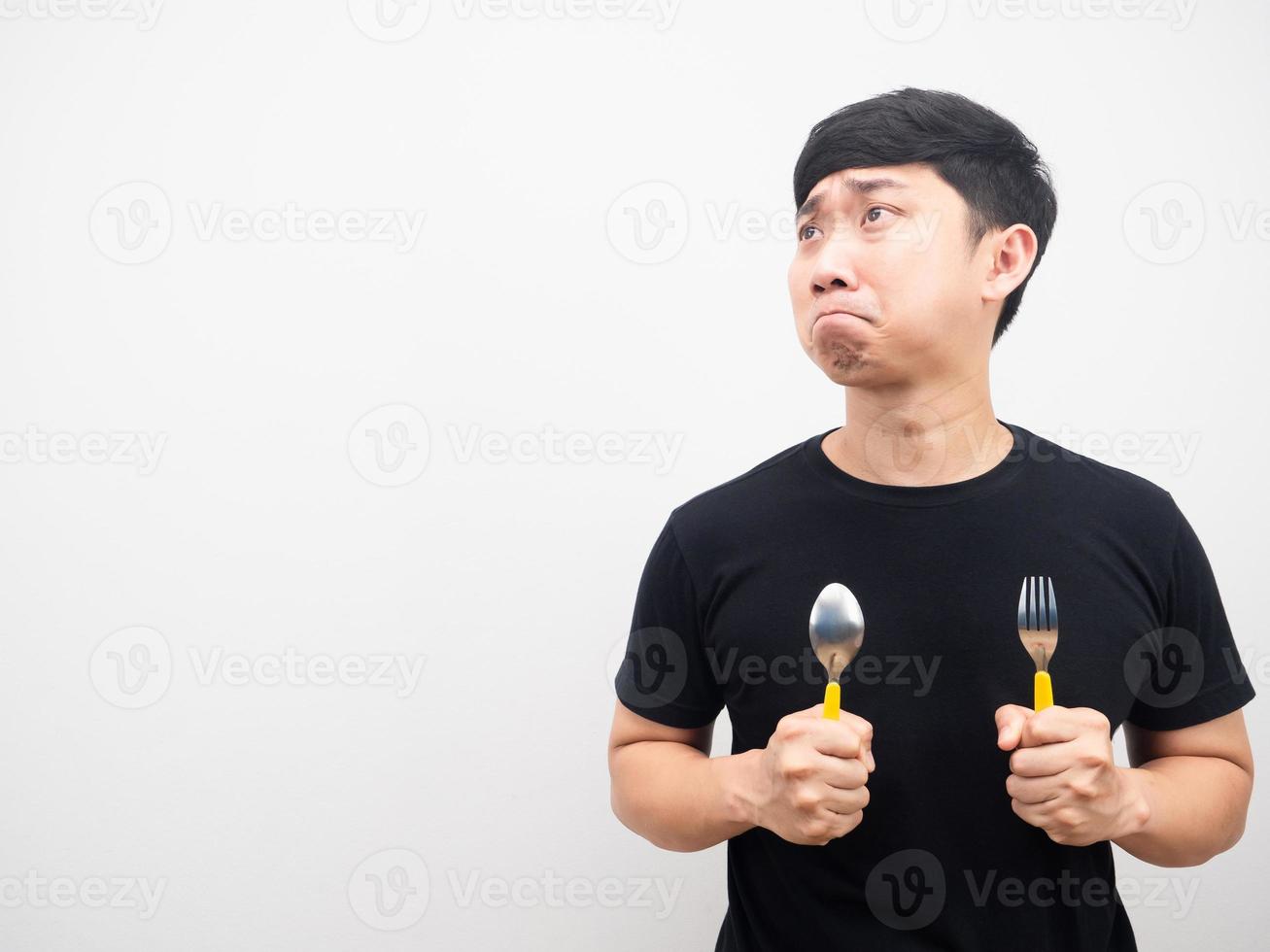 homem triste emoção e com fome segurando talheres olhando para o espaço da cópia foto