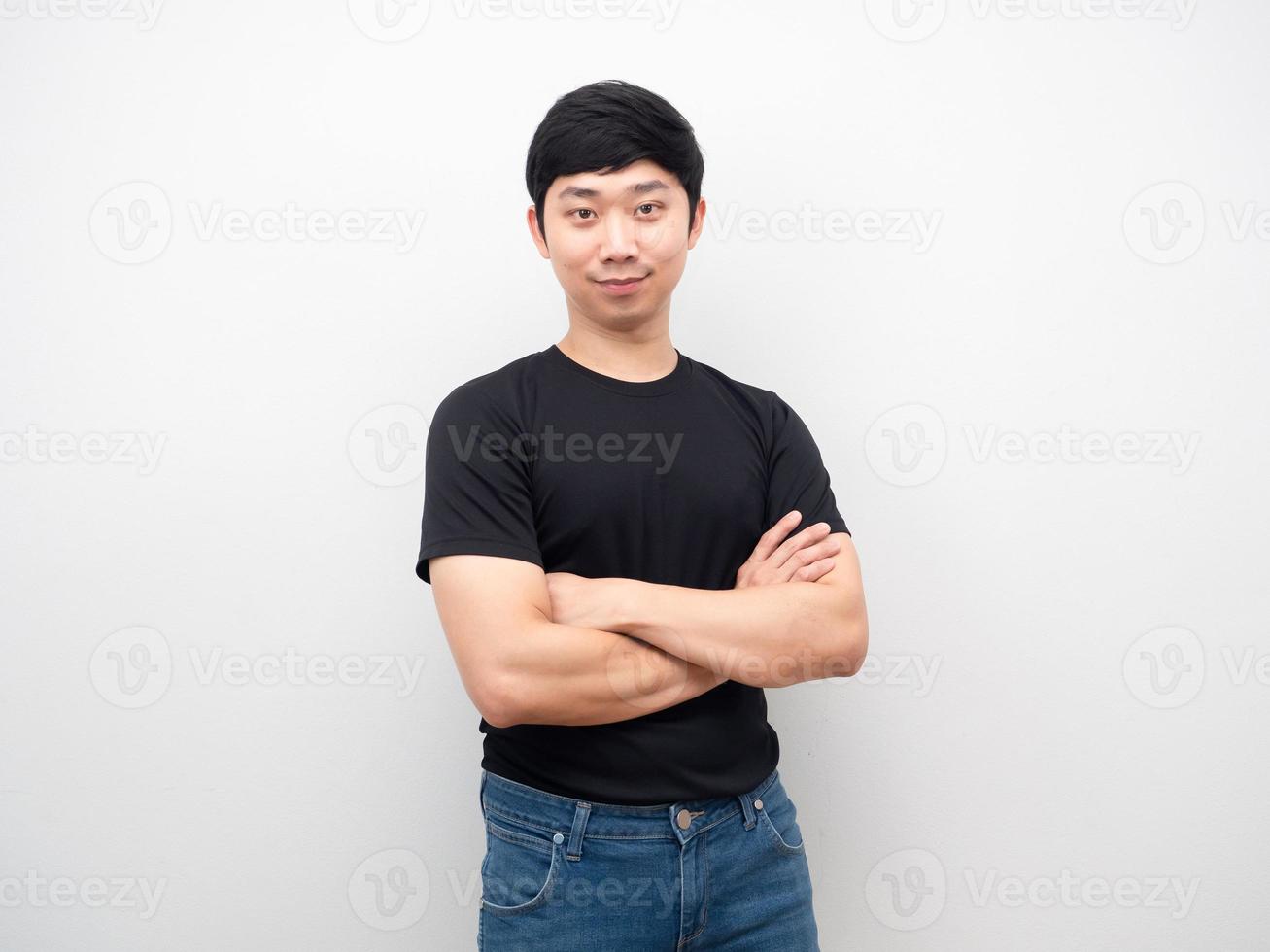 homem asiático camisa preta e jeans cruzam o braço com retrato de sorriso foto