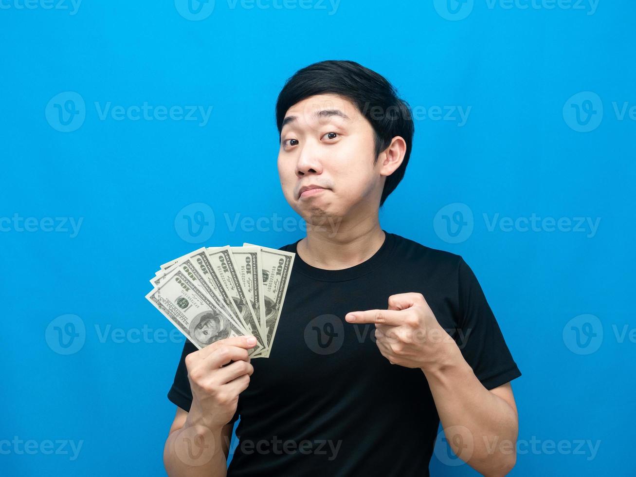 homem asiático gesto apontar o dedo para o dinheiro na mão emoção feliz foto
