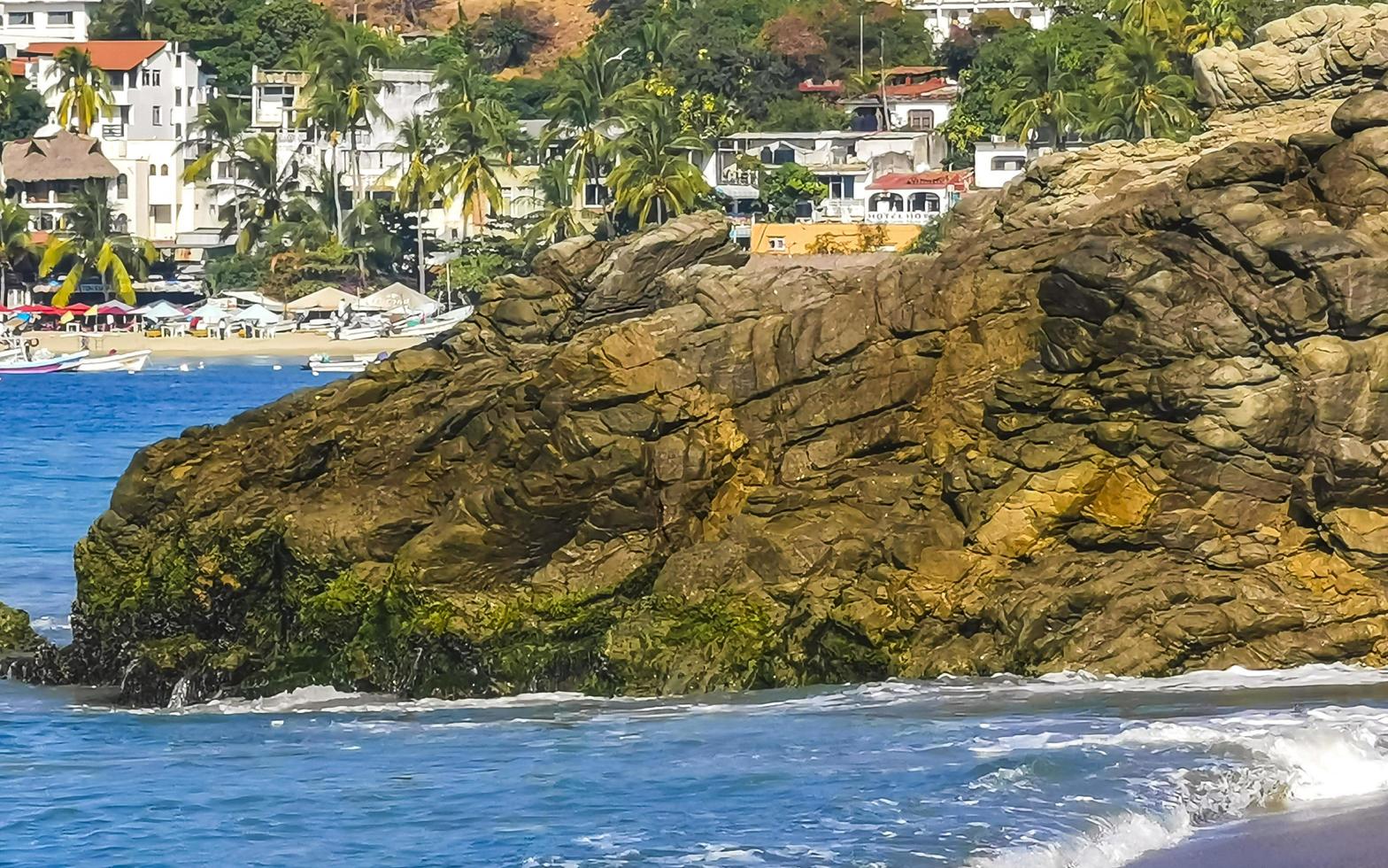 grandes ondas de surfista e rochas na praia puerto escondido méxico. foto