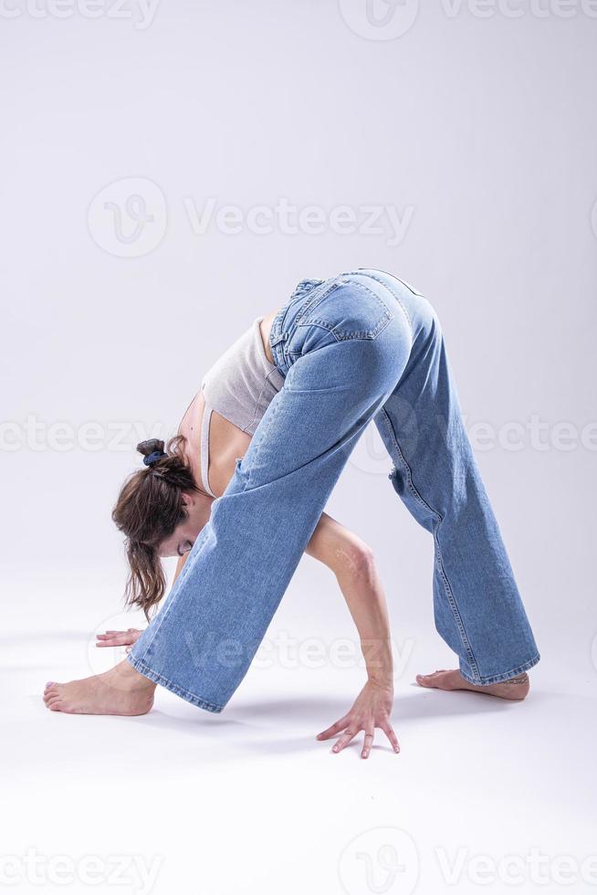 retrato de mulher jovem e bonita com corpo flexível atlético fazendo alongamento de perna. isolado foto