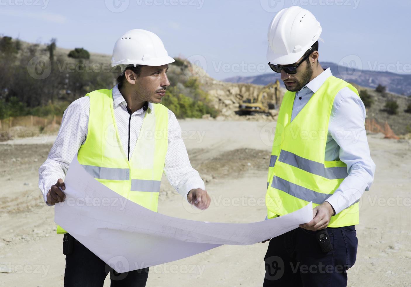 O engenheiro agrimensor está medindo o nível no canteiro de obras. topógrafos garantem medições precisas antes de realizar grandes projetos de construção. foto