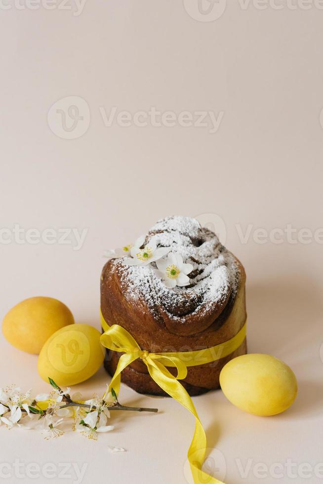 bolo de páscoa kraffin com canela e açúcar em pó. close-up de uma torta caseira com amarelo colorido e ovos de codorna foto