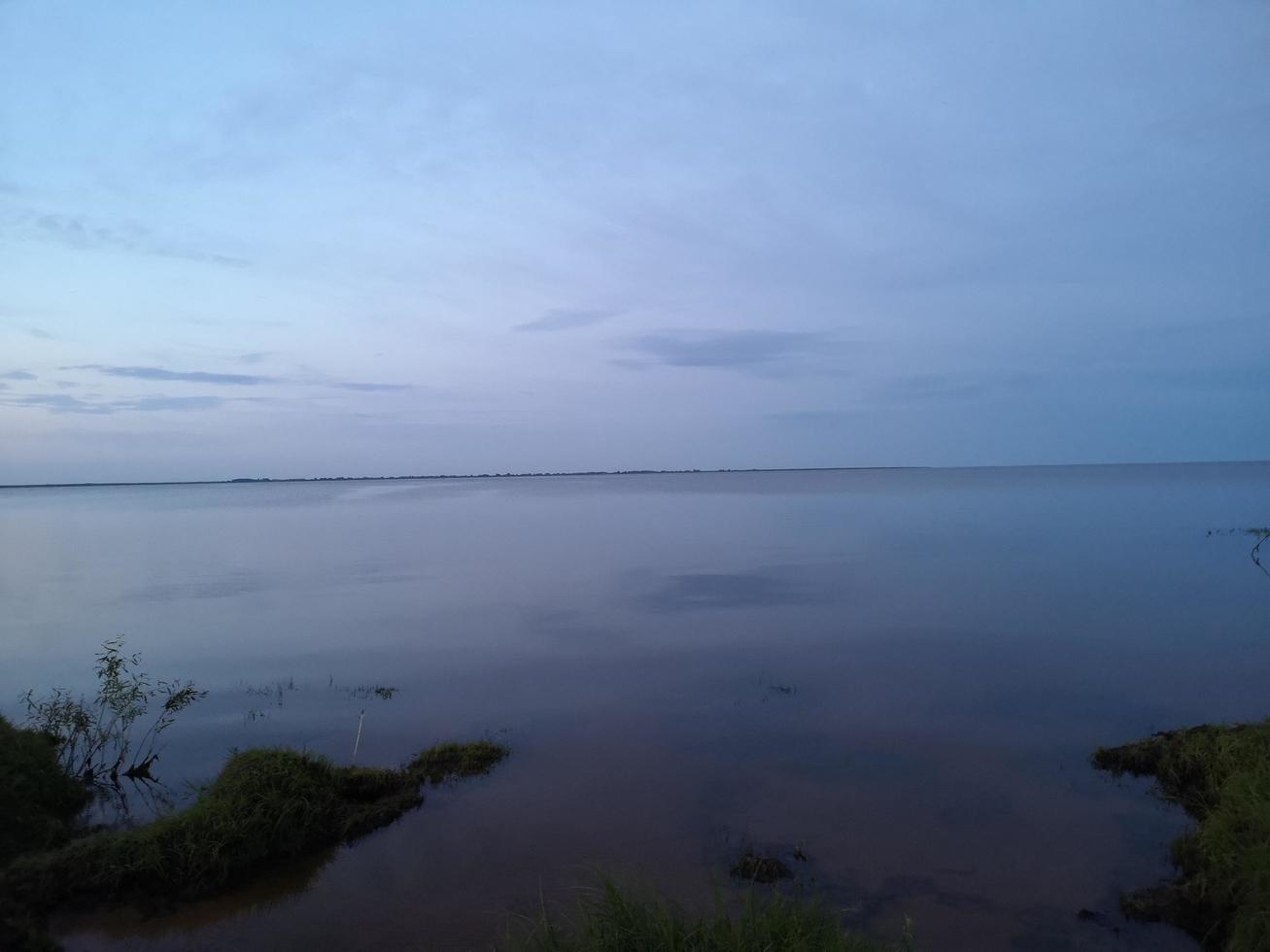 pôr do sol. céu noturno à noite no lago foto