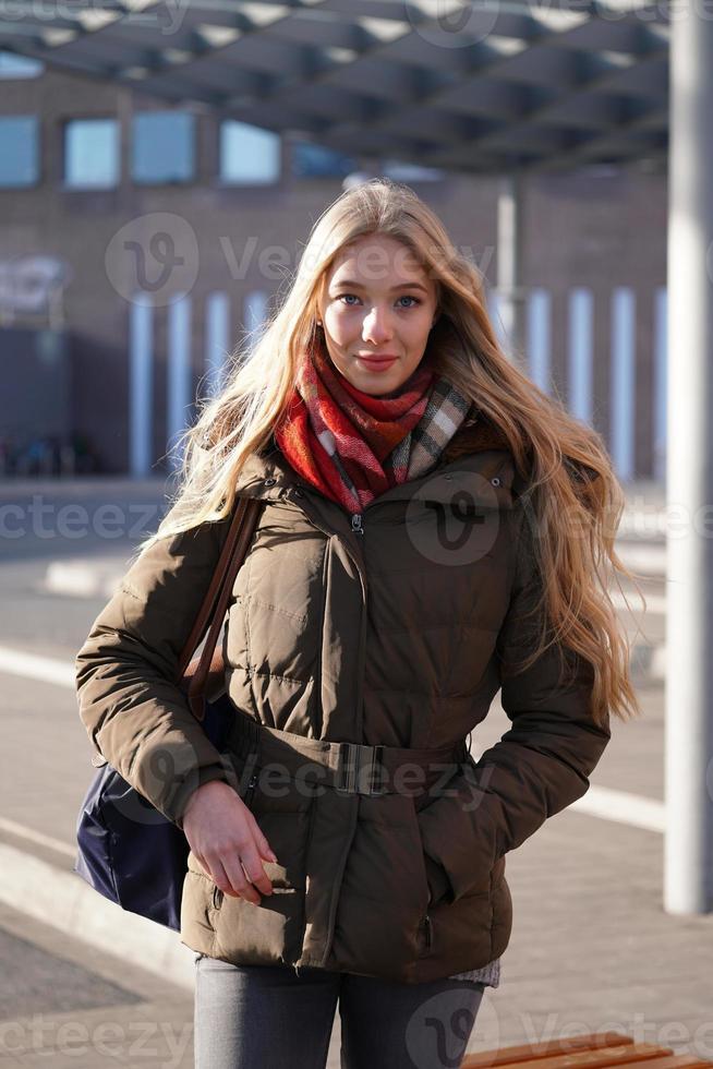 retrato de moda de estilo de rua de jovem esperando na estação de ônibus foto