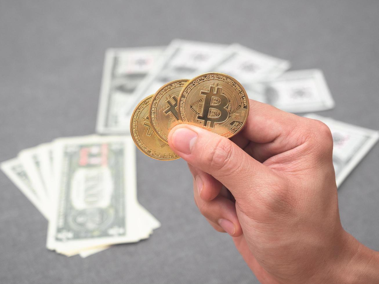mão segurando bitcoin dourado com o conceito de dinheiro digital de fundo de dinheiro foto
