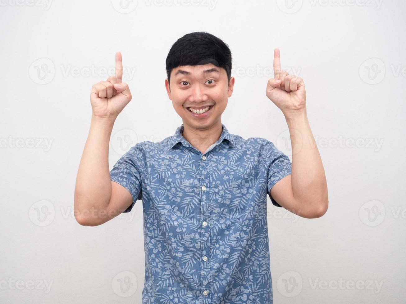 homem asiático camisa azul sorriso feliz apontar o dedo para baixo foto