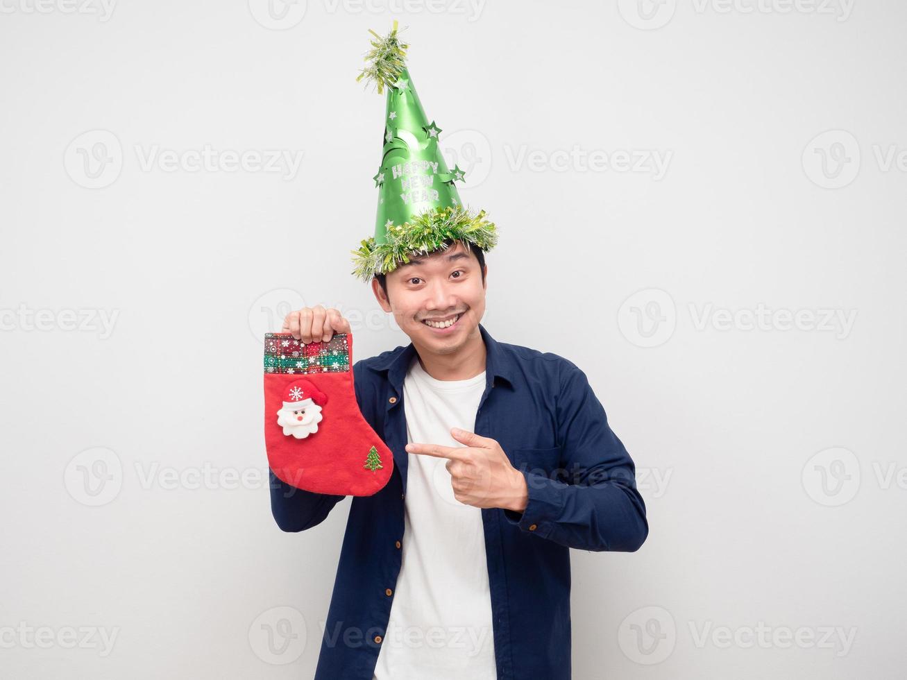 homem aponta o dedo para a meia de natal na mão fundo branco foto